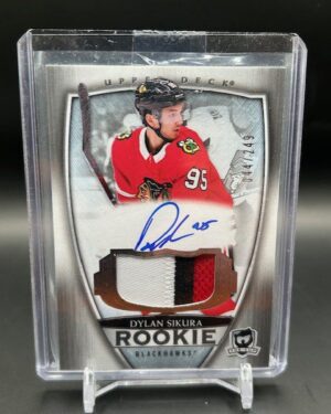 2018-19 Upper Deck The Cup Dylan Sikura Rookie Patch Auto /249 #102, featuring a bold on-card autograph and a vibrant multi-color Chicago Blackhawks patch, serial numbered out of 249, from Upper Deck’s high-end The Cup set.