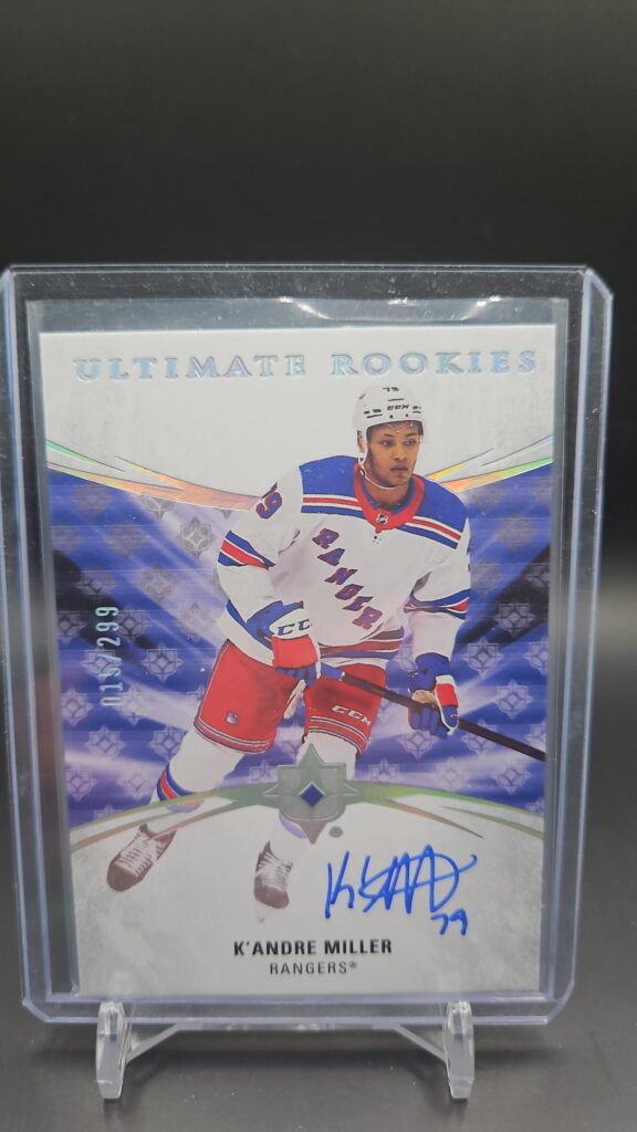 2020-21 Upper Deck Ultimate Collection K’Andre Miller Rookie Auto /299 #127, showing a bold on-card autograph, serial numbered out of 299, from the Ultimate Collection set, featuring the New York Rangers rookie in full uniform.