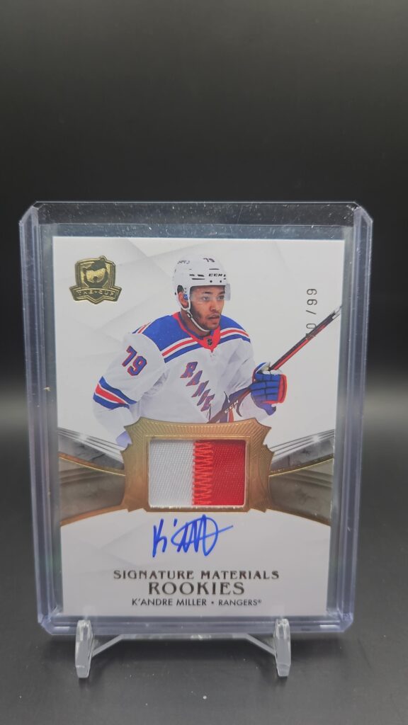 2020-21 Upper Deck The Cup K’Andre Miller Signature Materials Rookie Patch Auto /99, featuring a bold on-card autograph and a vibrant multi-color New York Rangers patch, serial numbered out of 99, from Upper Deck’s high-end The Cup set.