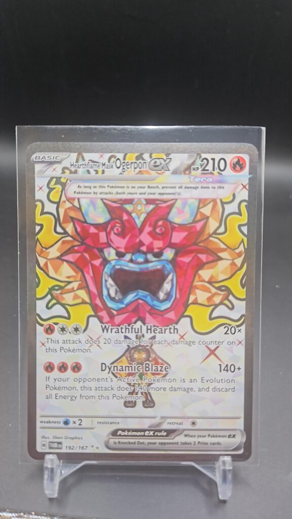 Pokémon TCG Hearthflame Mask Ogerpon ex 192/167 Twilight Masquerade Rare card displayed in near mint condition, showcasing unique mask design, detailed illustration, and collectible finish for fans.