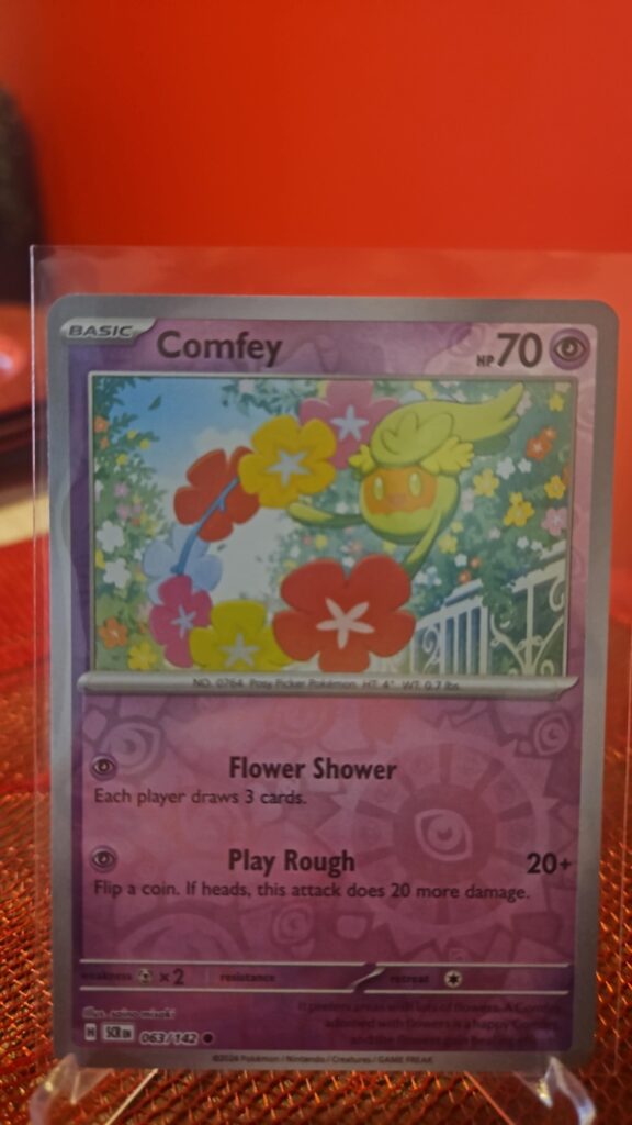 Comfey Reverse Holo Pokémon card from Pokémon TCG Stellar Crown, illustrated by Tika Matsuno, shown in Near Mint condition with reflective parallel‑foil background.