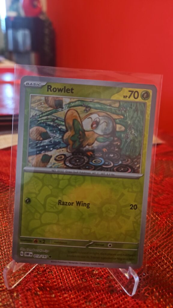Rowlet 13/197 Reverse Holo Pokémon card from Pokémon TCG Obsidian Flames, shown in Near Mint condition with reflective SV‑era foil pattern.