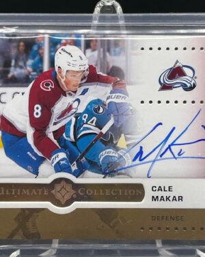 Front of 2025-26 Upper Deck Ultimate Collection Cale Makar Ultimate Emblems Autograph Gold hockey card serial numbered /25